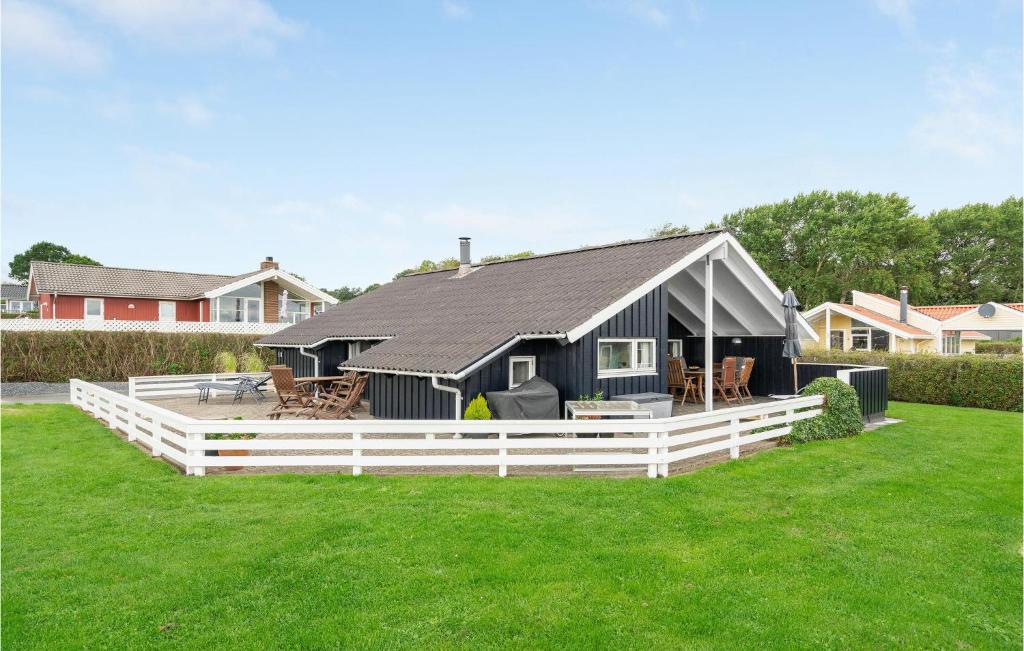 una casa negra con una valla blanca en un patio en Lovely Home In Sjlund With House Sea View, en Hejls