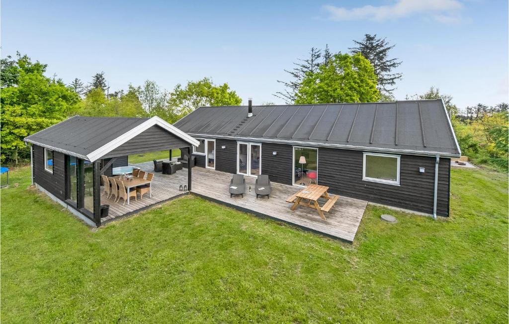 a black tiny house with a deck and a patio at Beautiful Home In Skjern With Sauna in Lem