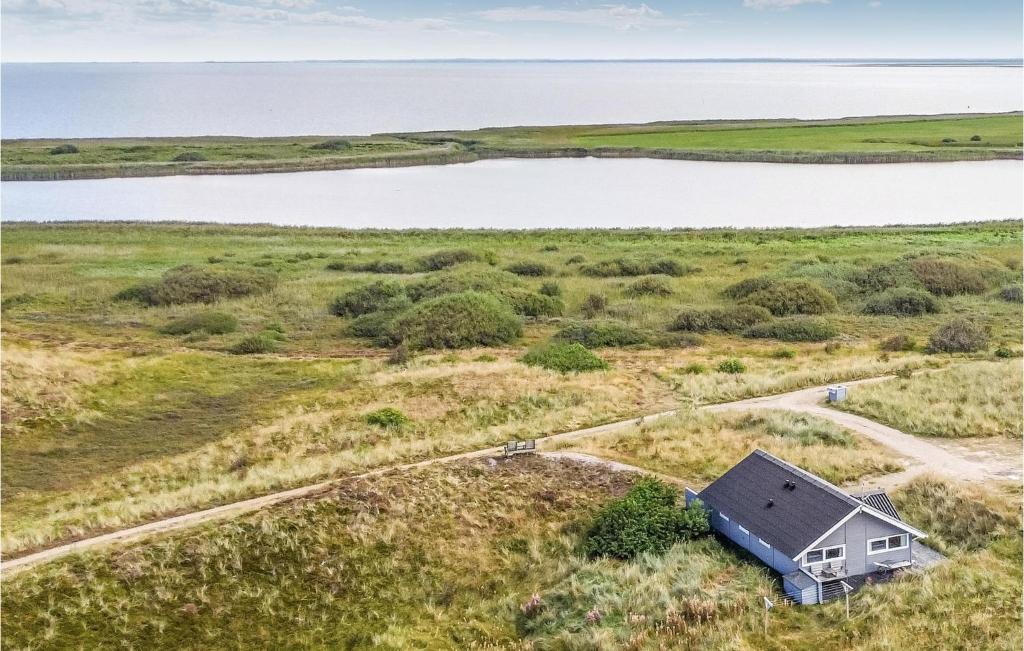 an aerial view of a house in a field with a lake at Pet Friendly Home In Hvide Sande With House Sea View in Havrvig
