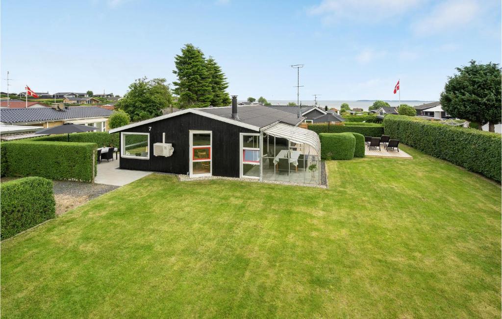 a black house on a yard with a green lawn at 3 Bedroom Awesome Home In Hejls in Hejls