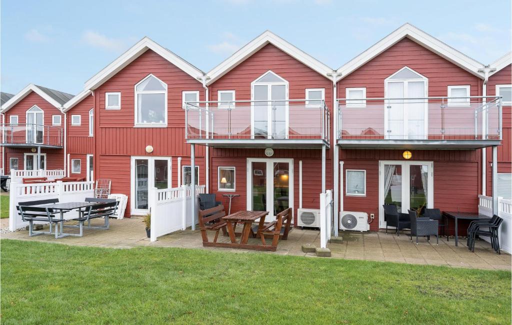 uma grande casa vermelha com um deque e um pátio em Beautiful Apartment In Hadsund With House Sea View em Hadsund