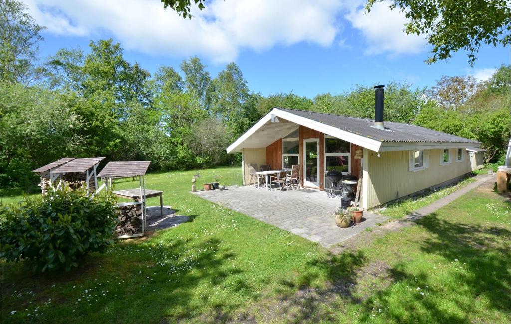 a small house in a yard with a patio at 3 Bedroom Awesome Home In Ebeltoft in Ebeltoft