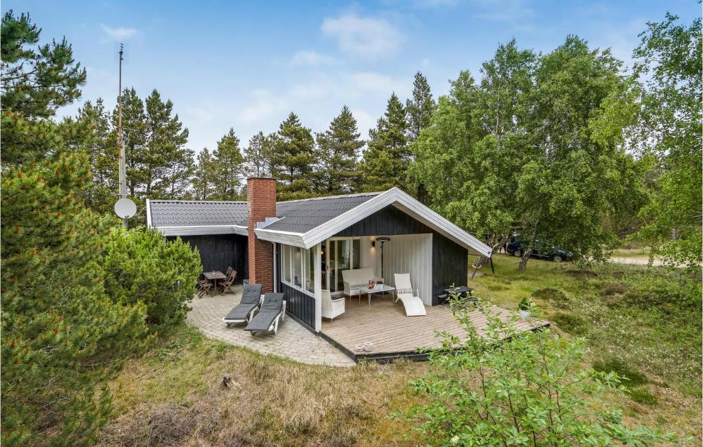 a small house with a deck in a field at Amazing Home In Rm With 3 Bedrooms And Wifi in Bolilmark