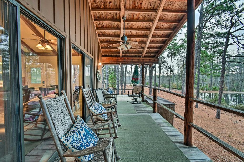 uma fila de cadeiras no alpendre de uma casa em Rockingham Cabin on 75 Acres with Lake Access! em Rockingham