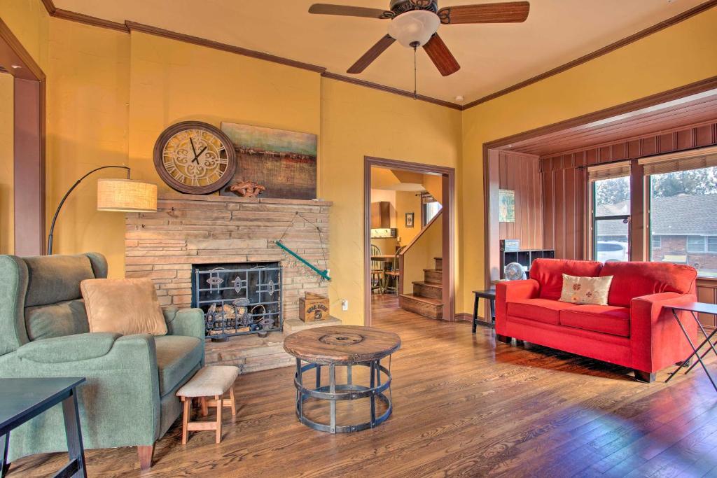 a living room with a red couch and a fireplace at Pet-Friendly OKC Home with Yard about 5 Mi to Dtwn! in Oklahoma City