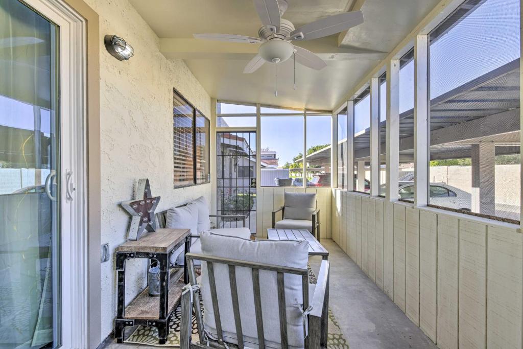 a porch with chairs and a ceiling fan at Downtown Gilbert Condo with Screened Porch! in Gilbert