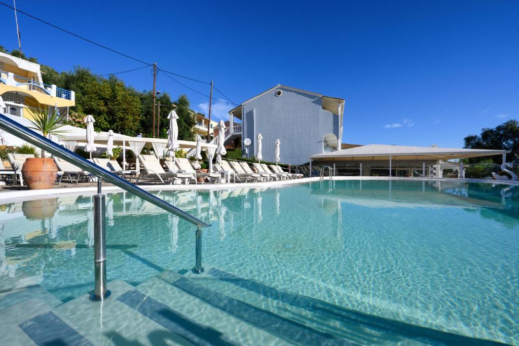 una gran piscina con sillas y un edificio en Kerkyra Island Hotel, en Mesongi