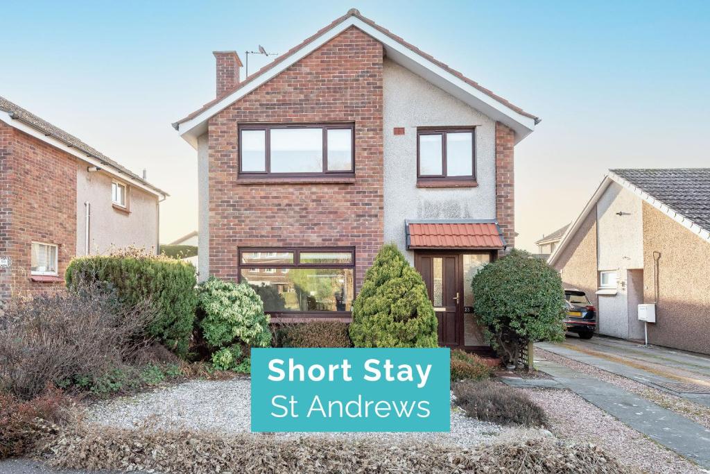 a brick house with a sign that says short stay st enaples at Radernie Place - 3 Bedroom House - Sleeps 6 in St. Andrews