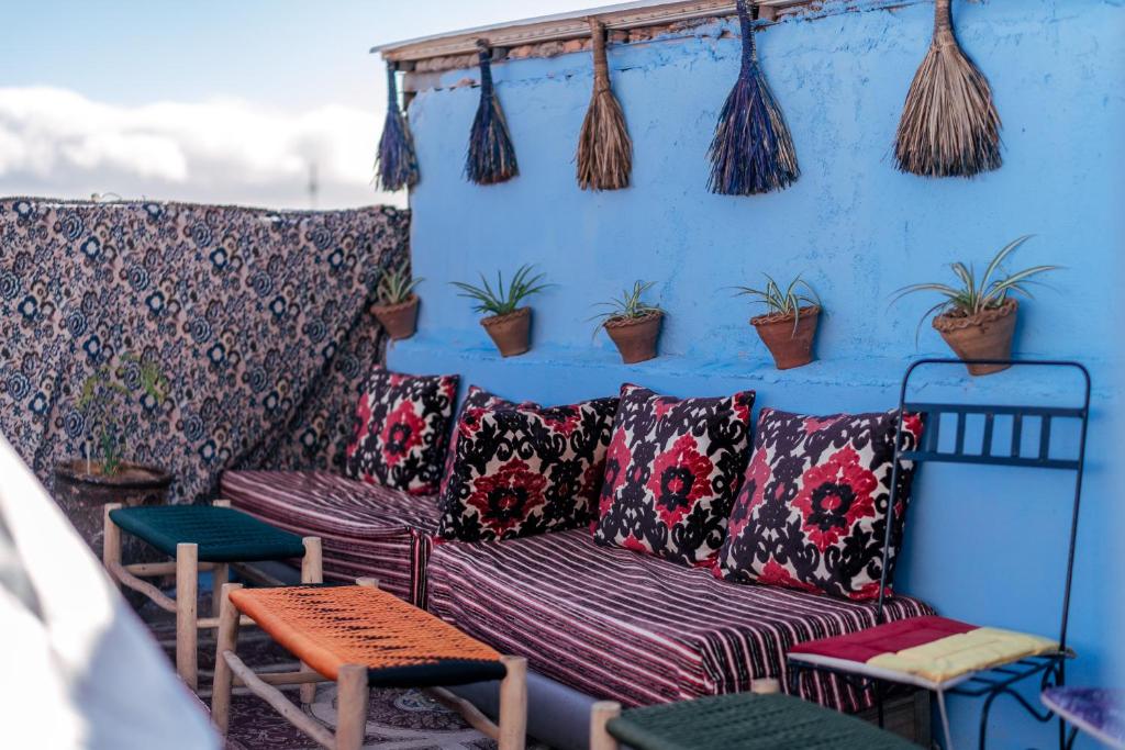 una pared azul con un sofá y algunas plantas en RIAD BORJ JAMAA LAFNA, en Marrakech