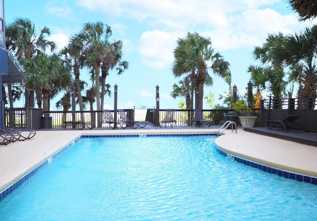 una piscina con palmeras en un complejo en Sun N Sand Resort en Myrtle Beach