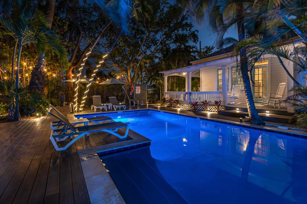 a swimming pool in front of a house at night at Papa's Hideaway in Key West