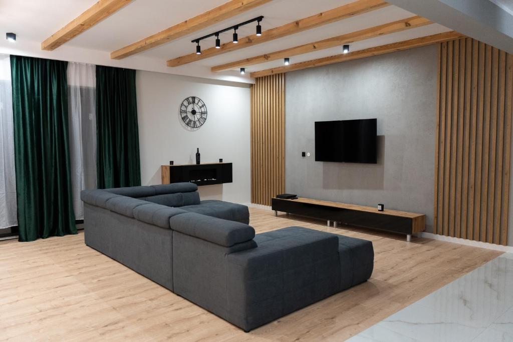a living room with a couch and a flat screen tv at Dom przy molo in Augustów