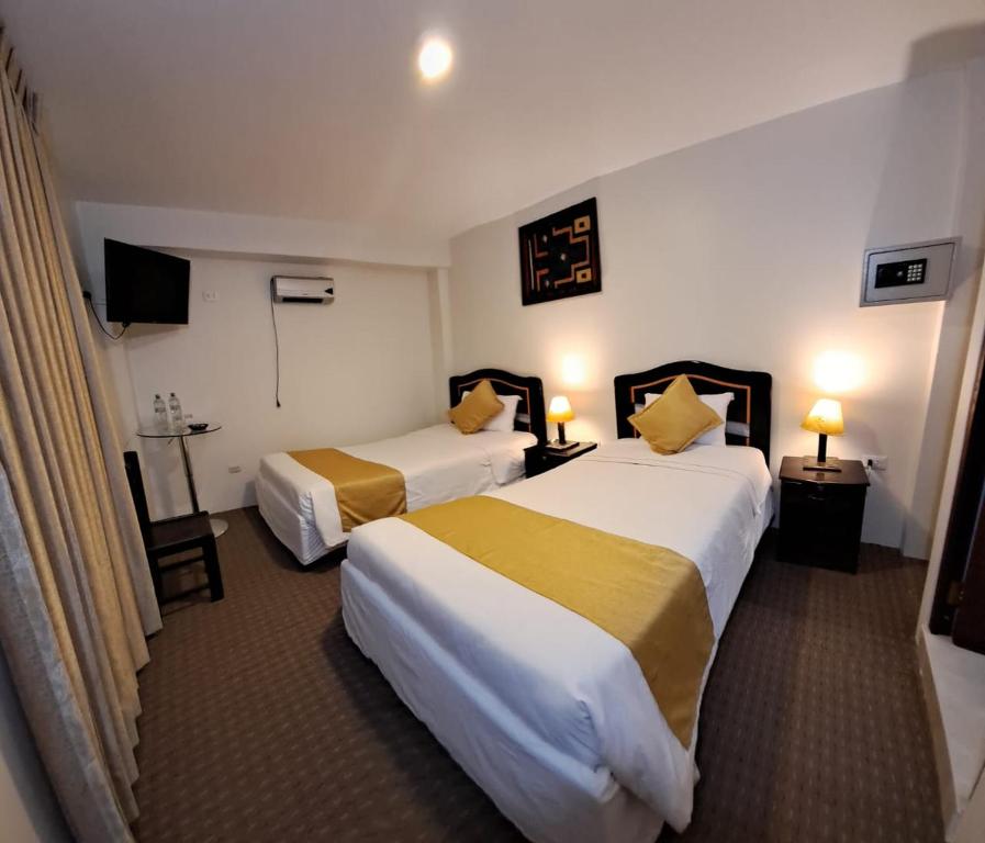 Habitación de hotel con 2 camas y TV en Real Excelencia, en Machu Picchu