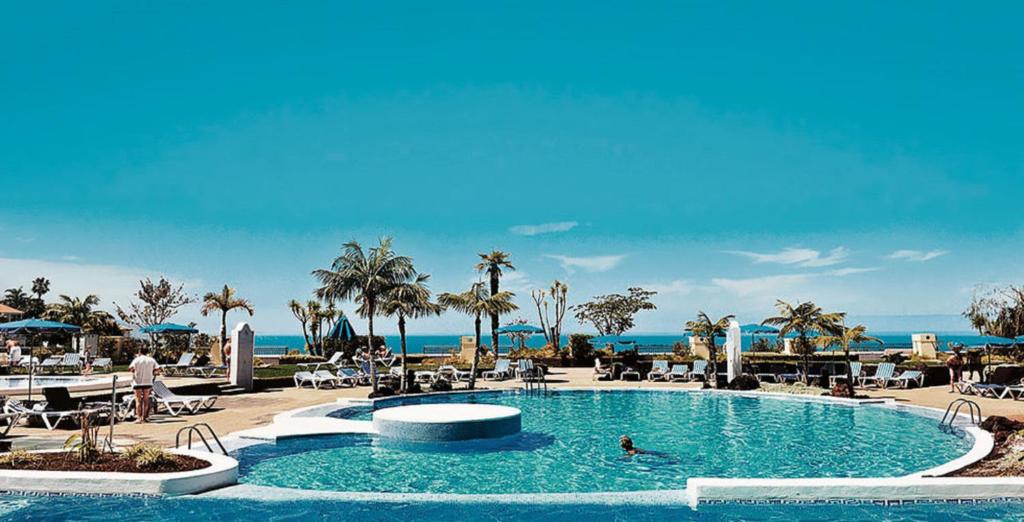 a pool at a resort with people swimming in it at Residencial La Quinta Park Suites in Santa Úrsula