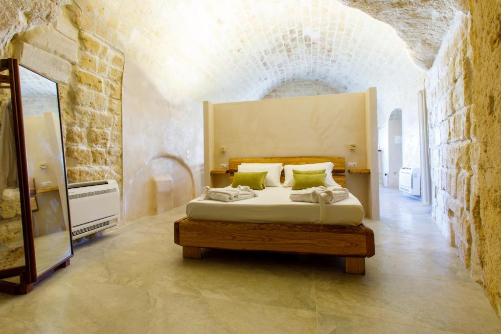 ein Schlafzimmer mit einem Bett in einer Ziegelwand in der Unterkunft Casa Vacanza La Cava nel Barisano Suite Matera in Matera