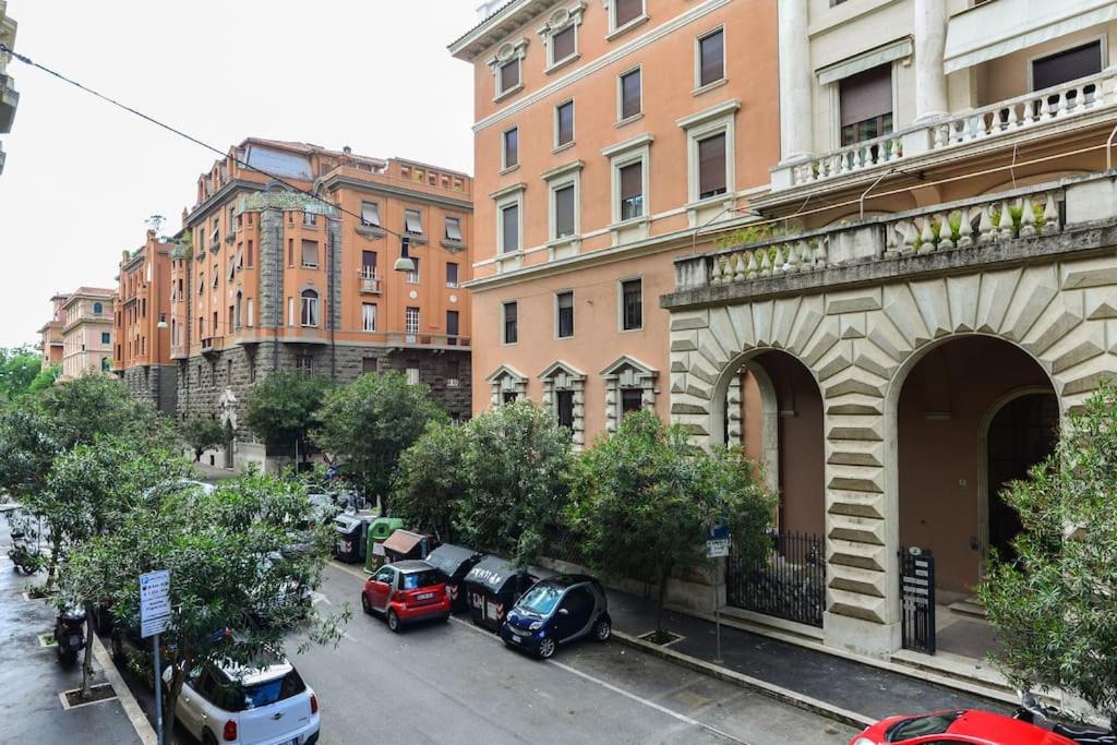 uma rua da cidade com carros estacionados em frente aos edifícios em Flaminia71 em Roma