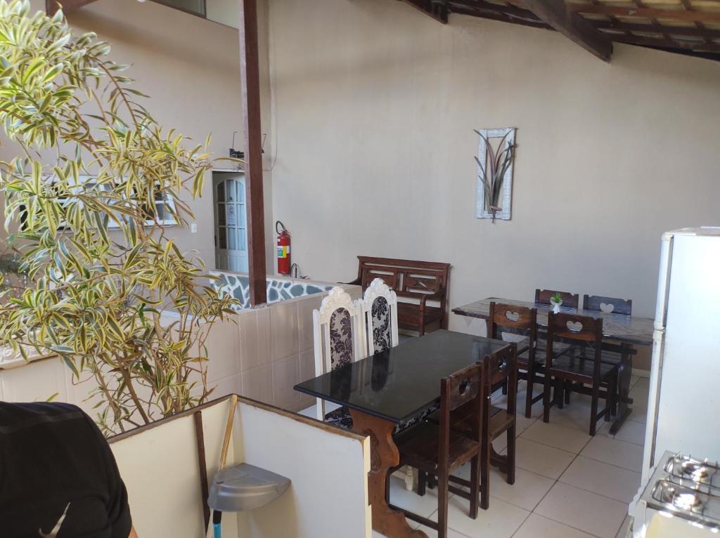 uma sala de jantar com uma mesa e cadeiras e um frigorífico em Pousada nascente do sol em Macaé