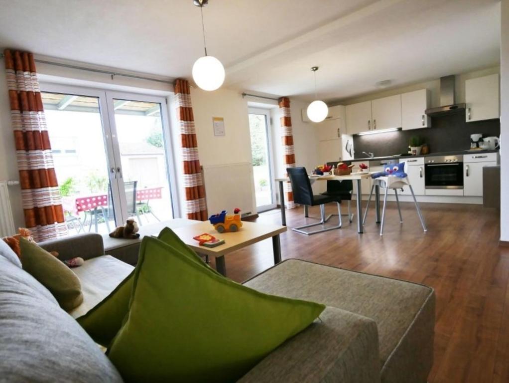 a living room with a couch and a kitchen at Ferienwohnung 1 in Ochsenhausen