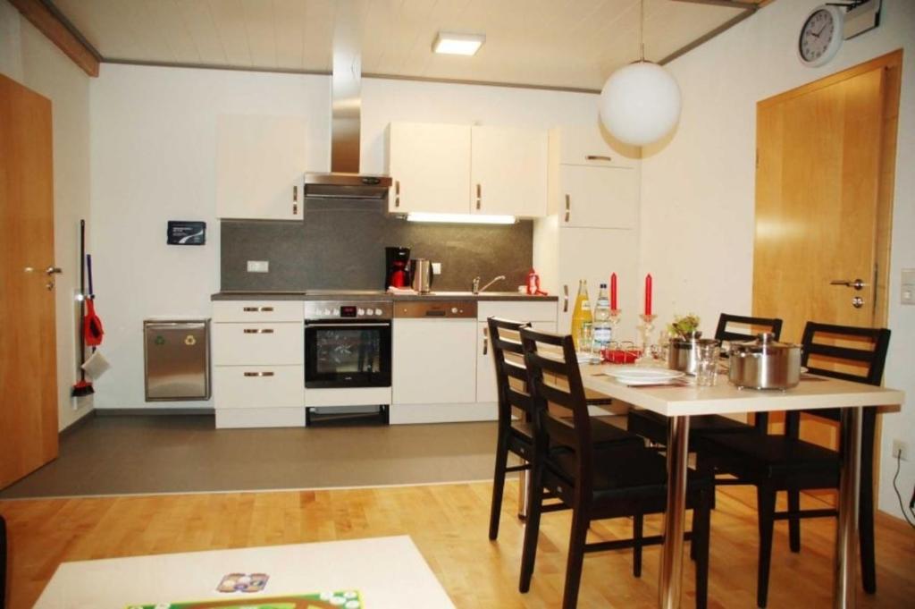 een keuken met een tafel en stoelen in een kamer bij Ferienwohnung 8 in Ochsenhausen