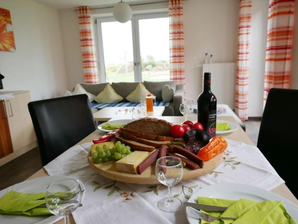una mesa con un plato de comida y una botella de vino en Ferienwohnung 2, en Ochsenhausen