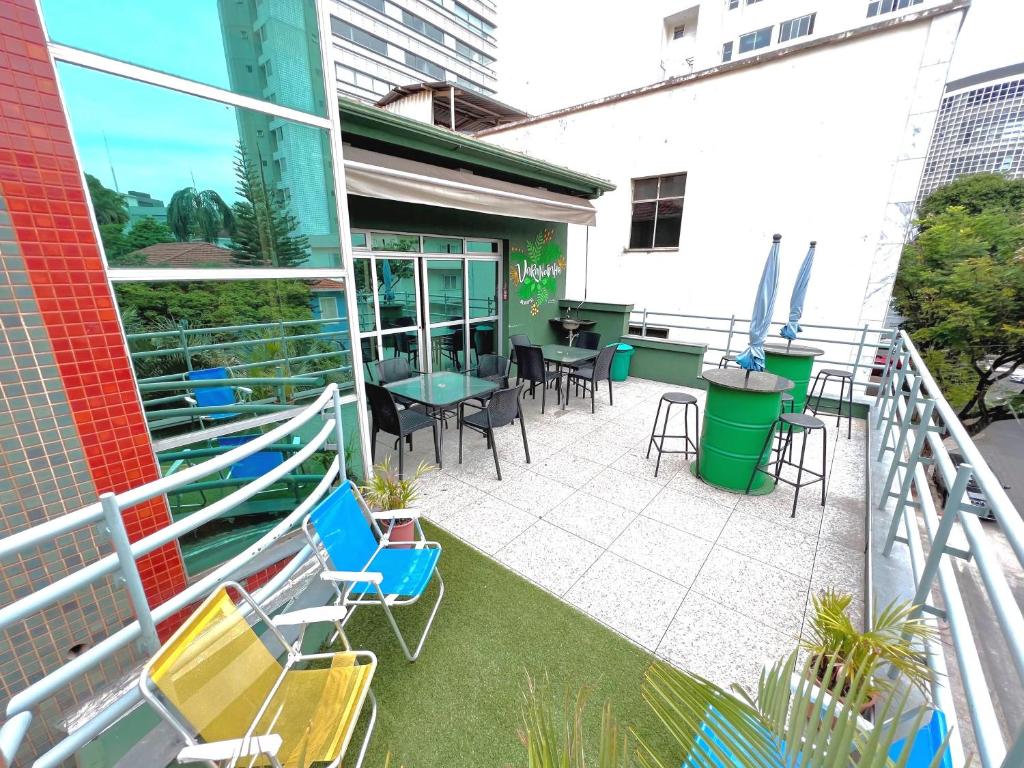 a balcony with chairs and tables on a building at Br Hostel in Belo Horizonte