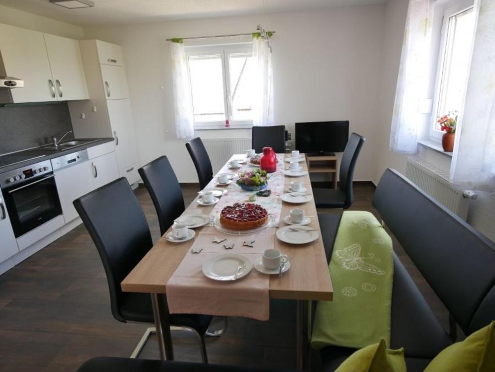 uma sala de jantar com uma mesa longa e cadeiras em Ferienwohnung 11 em Ochsenhausen