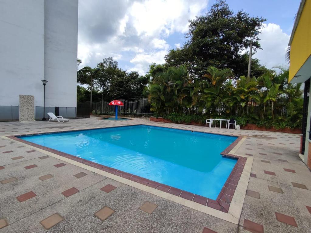 a swimming pool with blue water in a yard at Habitación privada con vista a la ciudad in Pereira