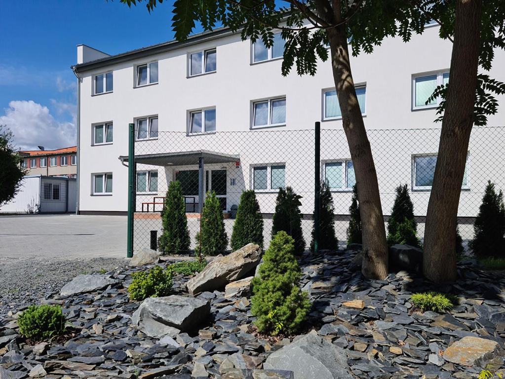 un edificio blanco con árboles delante de él en Penzion Barborka en Olomouc