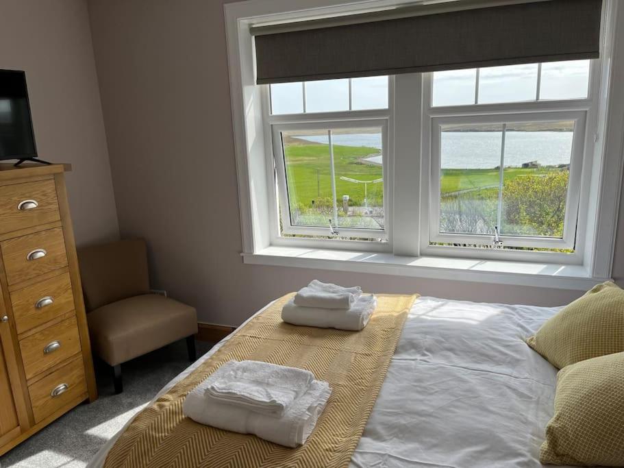Un dormitorio con una cama y una ventana con toallas. en Bixter House - a spacious self-catering property 