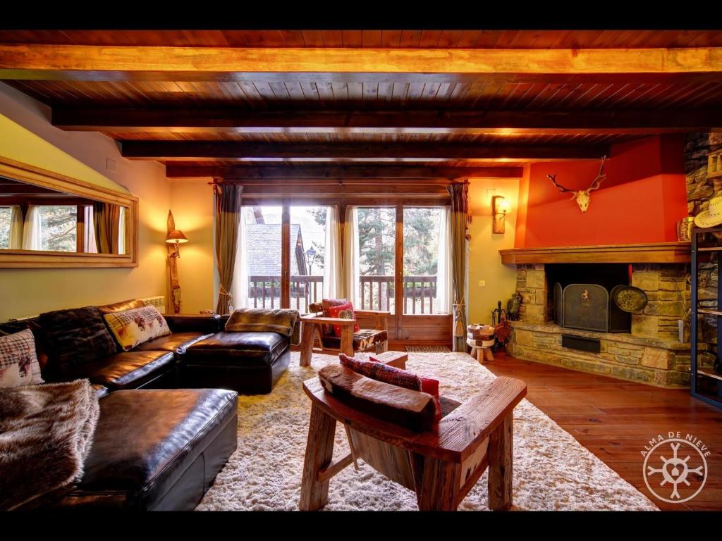sala de estar con sofá y chimenea en CERVI de Alma de Nieve, en Bagergue