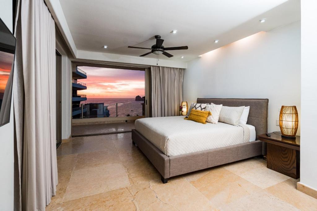 a bedroom with a bed and a large window at Ocean view 4 min walk to Medano Beach in Cabo San Lucas