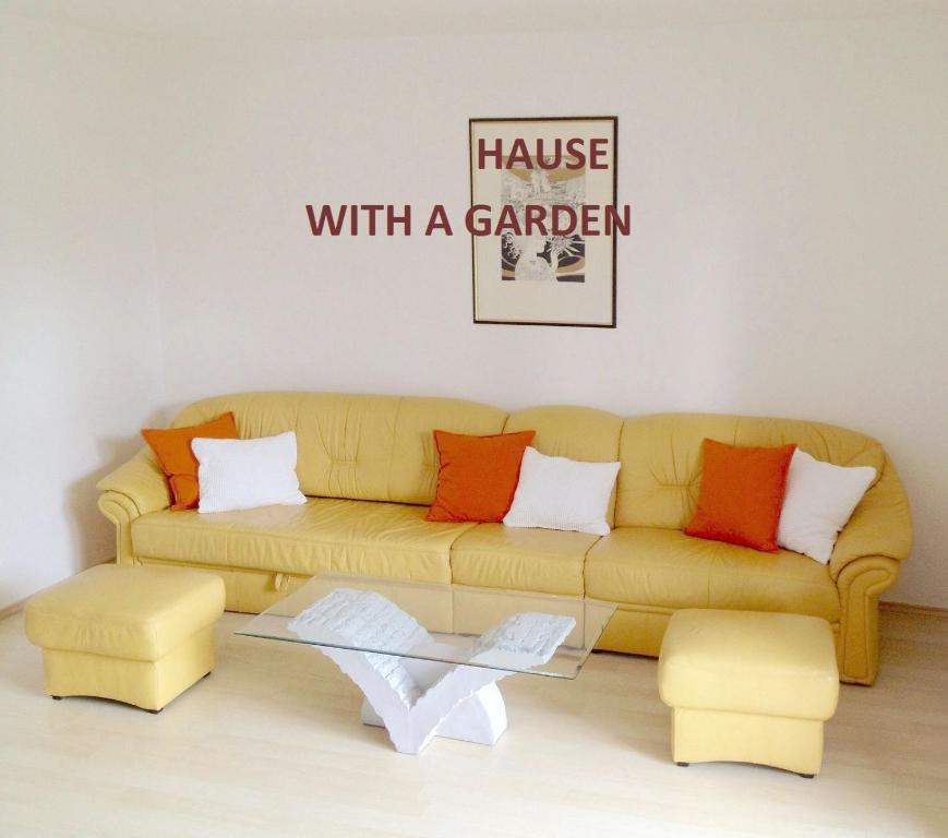 una sala de estar con sofá y un cartel que lee la casa con jardín en Flair Apartmanház en Eger