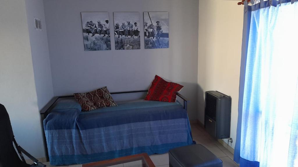 1 dormitorio con 1 cama y una foto en la pared en Alquileres Pedro en Olavarría