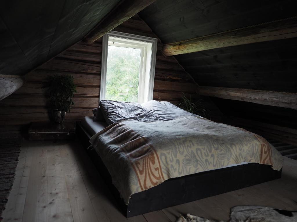 Cama grande en habitación con ventana en Stabburet, Lensmannsgården en Namsos