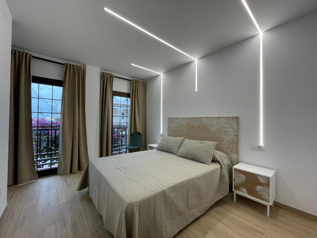 1 dormitorio blanco con 1 cama grande y ventanas en APCOSTAS - Marino Las Fuentes Superior, en Alcossebre