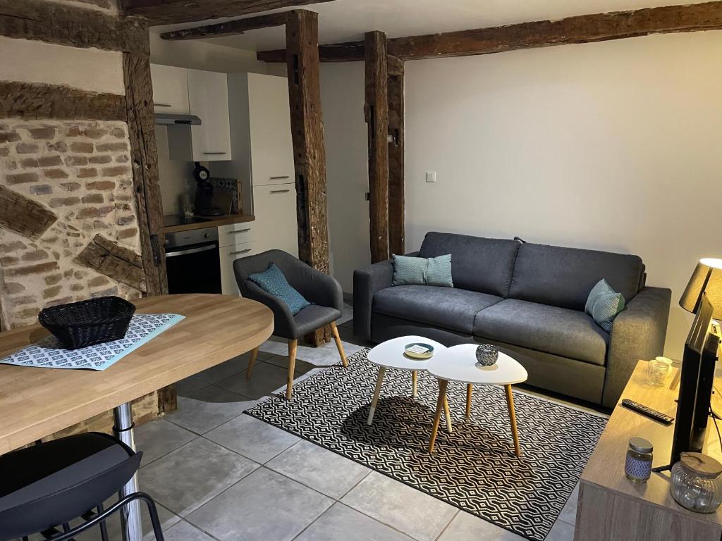 sala de estar con sofá y mesa en Joli appartement quartier historique en Moulins