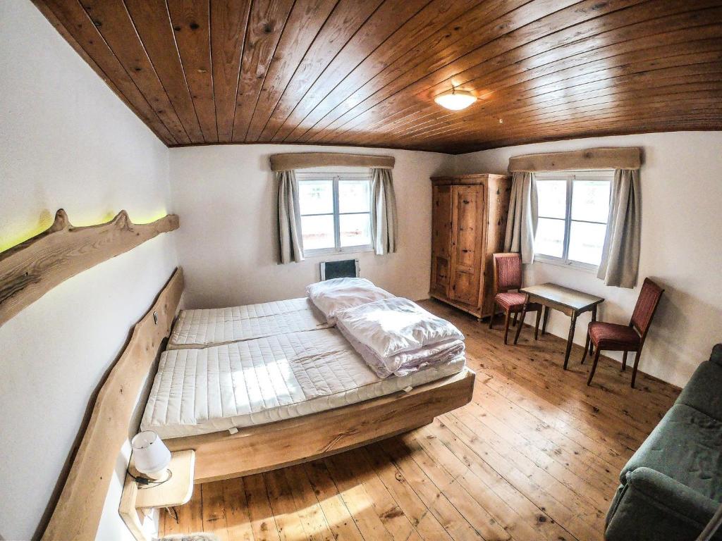 een slaapkamer met een groot bed in een kamer met houten plafonds bij Ferienhaus Kaltenbrunn in Ellmau