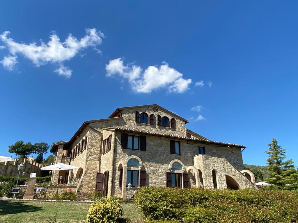 貝瓦尼亞的住宿－Antico Borgo Carceri & Wellness，一座蓝色天空的大石头建筑