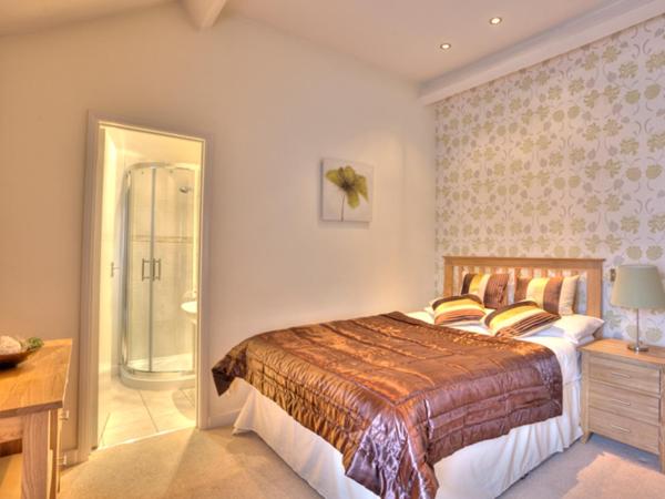 a bedroom with a large bed and a walk in shower at The Carlton in Rugby