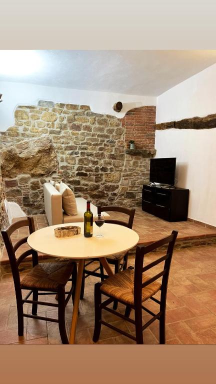 uma mesa e cadeiras com uma garrafa de vinho em La mia casa nel Borgo em Scarlino
