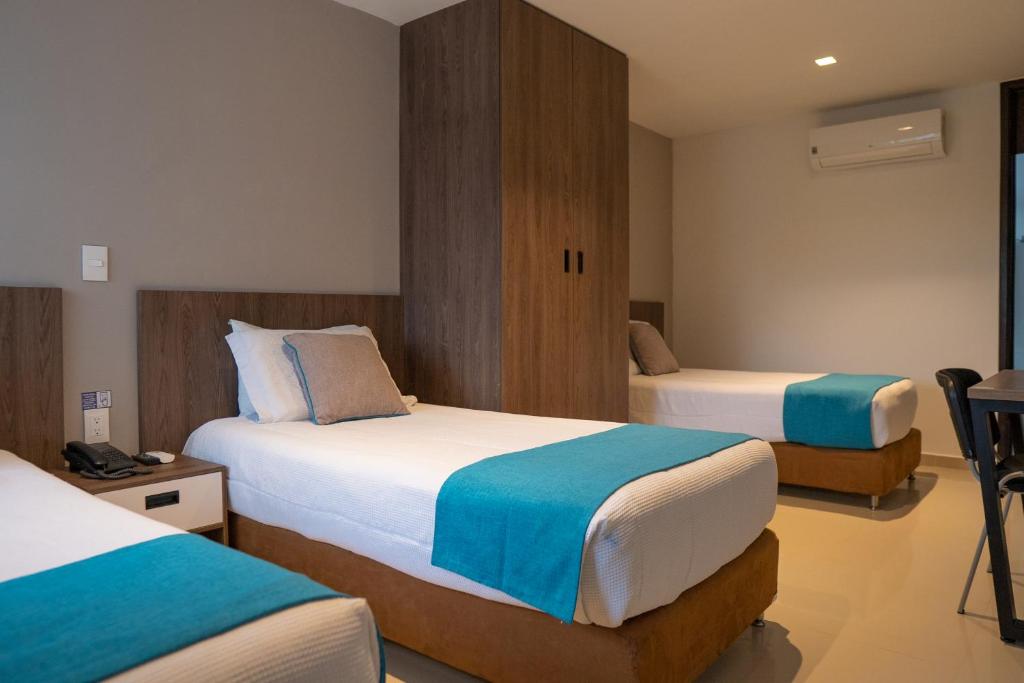 ein Hotelzimmer mit 2 Betten in einem Zimmer in der Unterkunft Hotel San Gabriel in Barrancabermeja
