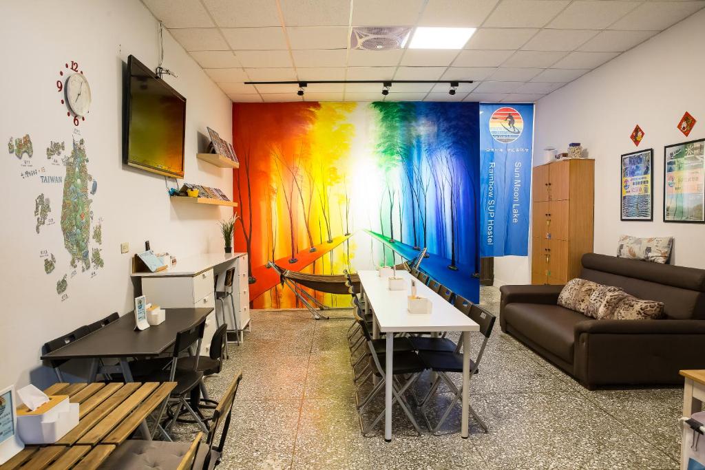 ein Zimmer mit einem Sofa und einer farbenfrohen Wand in der Unterkunft 日月彩舟 日月潭背包客旅店 Sun Moon Lake Rainbow SUP Hostel in Yuchi