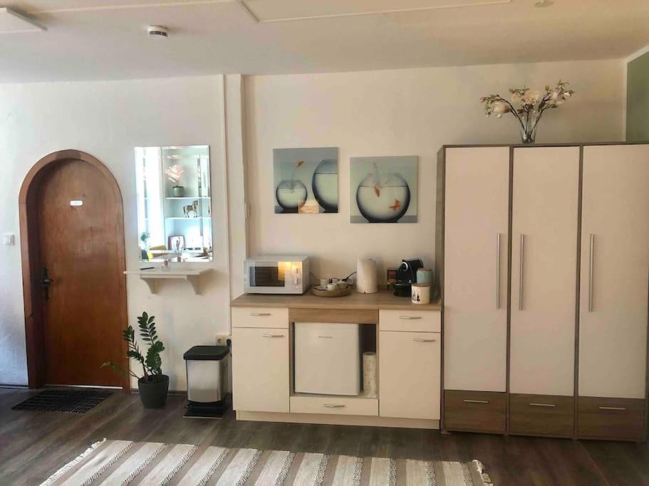 a kitchen with a white cabinet and a microwave at Studio Emdecker am Delft in Emden