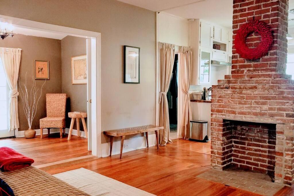 sala de estar con chimenea de ladrillo y sofá en Historic 2-Bedroom Cloverdale Cottage, en Montgomery