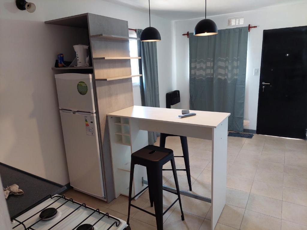 a kitchen with a white table and a refrigerator at Las3B 6 in General Roca