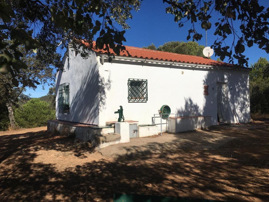 un edificio blanco con una estatua delante de él en Cortijo andaluz en Sierra Morena - Naturaleza, en Villaviciosa de Córdoba