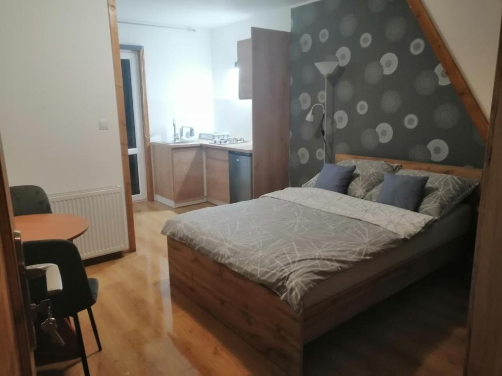 een slaapkamer met een bed, een tafel en een bureau bij Pokoje Gościnne Przy Lesie in Pobiedna
