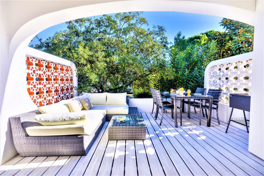 un patio avec un canapé et une table sur une terrasse dans l'établissement Vale do Lobo Apartment B, à Vale do Lobo