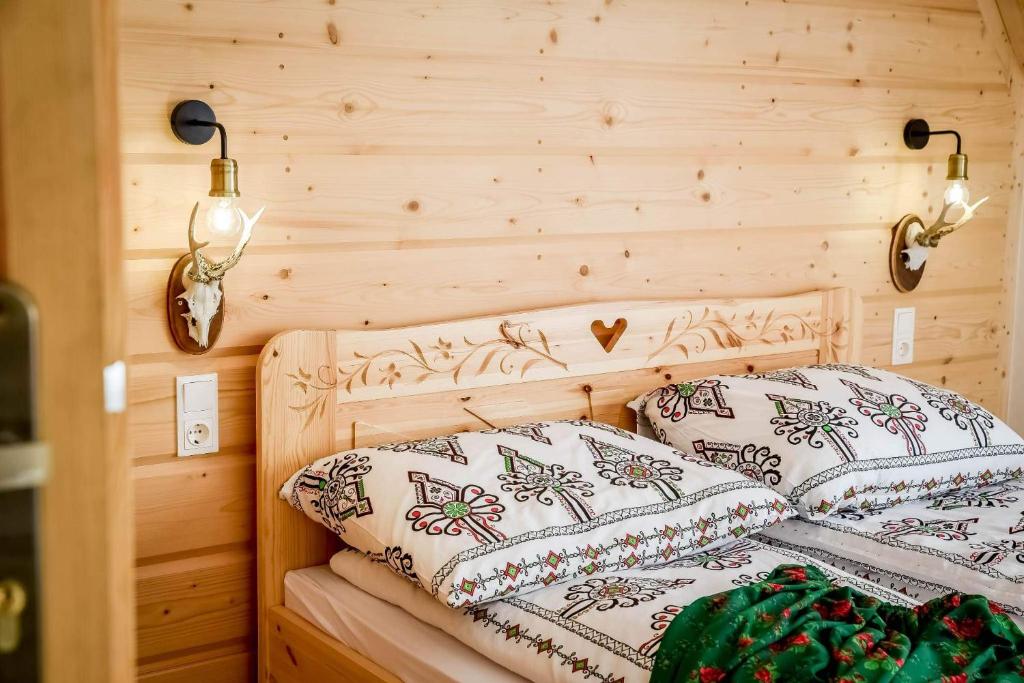 two pillows on a bed in a wooden room at Apartamenty u Burego in Biały Dunajec