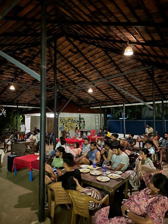 um grupo de pessoas sentadas em mesas em um restaurante em Soul, Varkala - Black Beach em Varkala